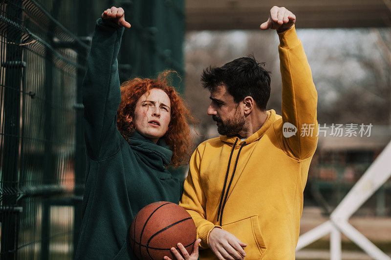 一对热爱运动的年轻夫妇正准备打篮球。