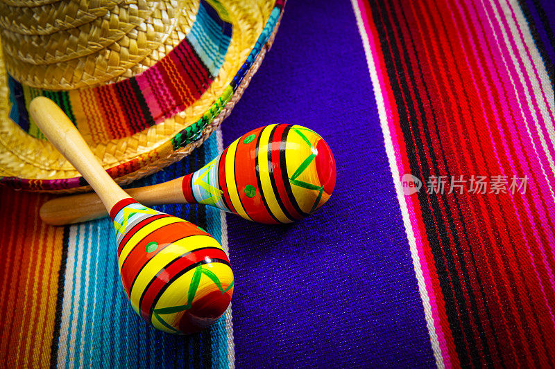 五月五日节快乐，戴着墨西哥宽边帽，在彩色墨西哥毯子上放着两颗沙球