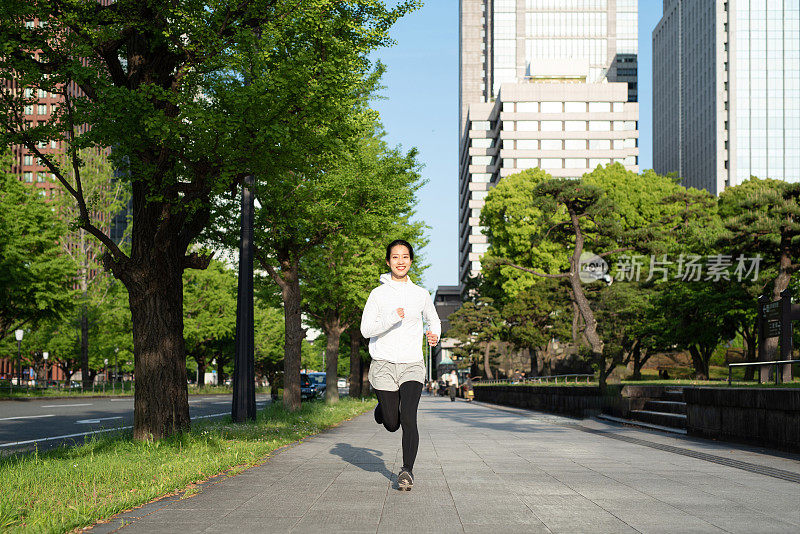 年轻女子在城市街道上奔跑