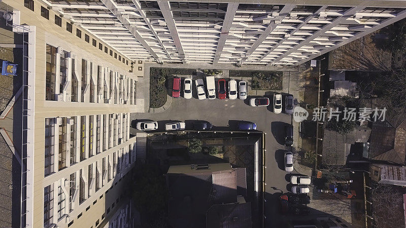 庭院内停放车辆的多层建筑屋顶的俯视图。夹。带庭院的多层建筑水平俯视图