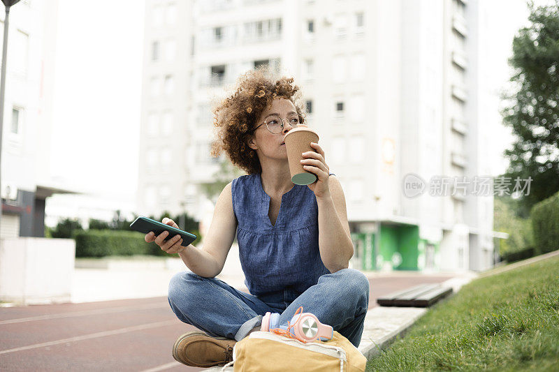 一名年轻女子在户外喝咖啡的肖像