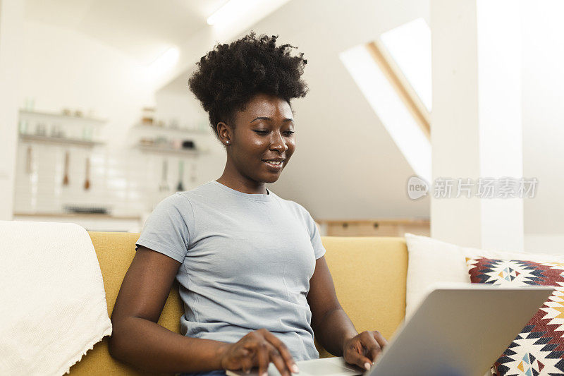 一位快乐的非洲妇女的肖像在她的客厅在线工作