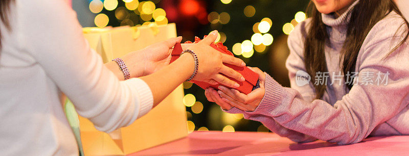近距离牵手，跨年夜交换新年礼物。圣诞节或新年的礼品盒