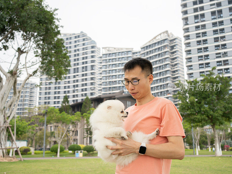 男主人抱着他的宠物狗