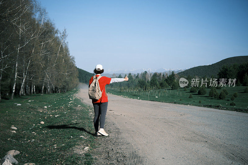 女背包客在山路上搭车