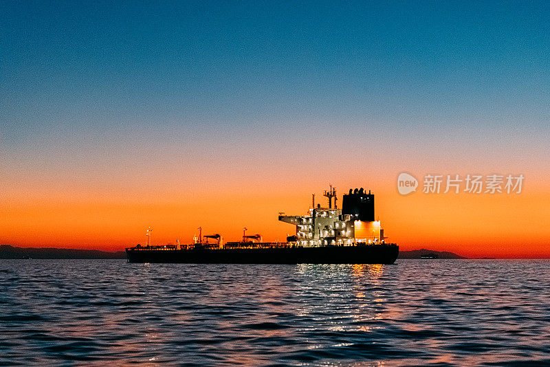 日落时的空货船，背景是卡塔利娜岛——南加州海岸的许多空货船之一