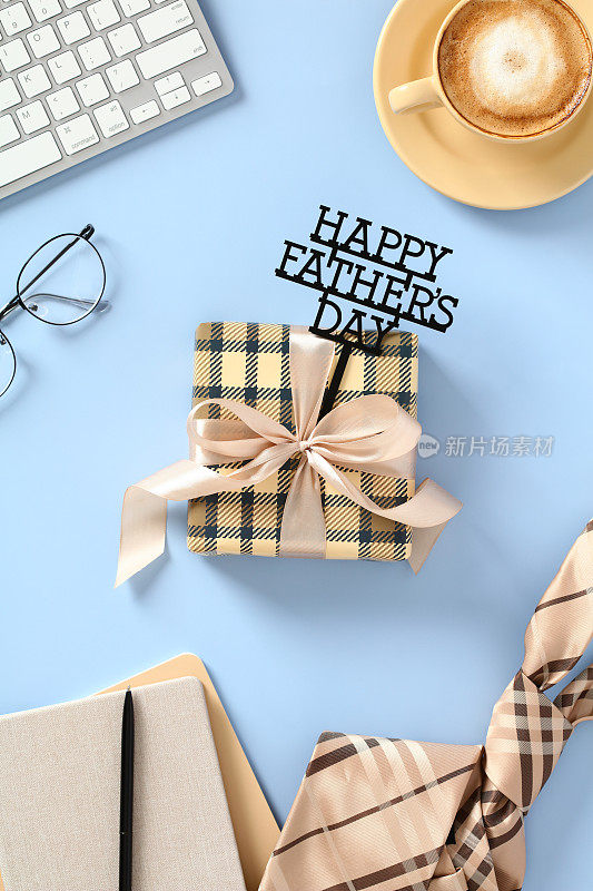 父亲节快乐垂直横幅，包括礼盒，咖啡杯，领带，眼镜，键盘，蓝色背景的纸质笔记本。