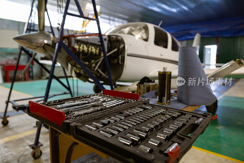 机库是一家小型汽车修理店。多功能汽车修理工工具套装。轻型单发飞机，需要维修发动机。