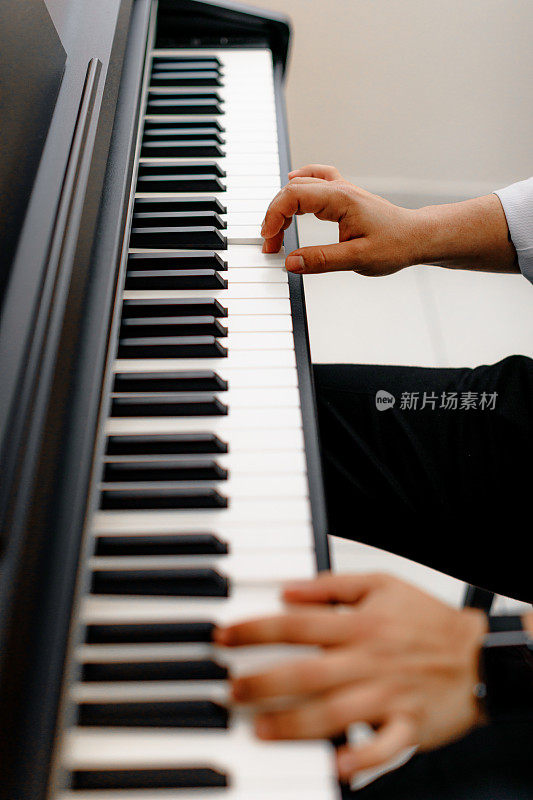 深情的旋律:一个人在钢琴上创作音乐的手