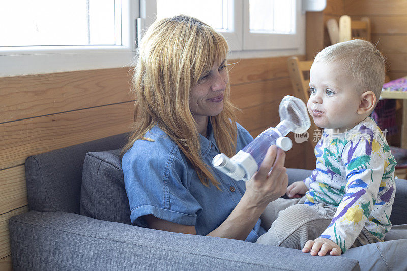 母亲鼓励她的孩子使用哮喘吸入器