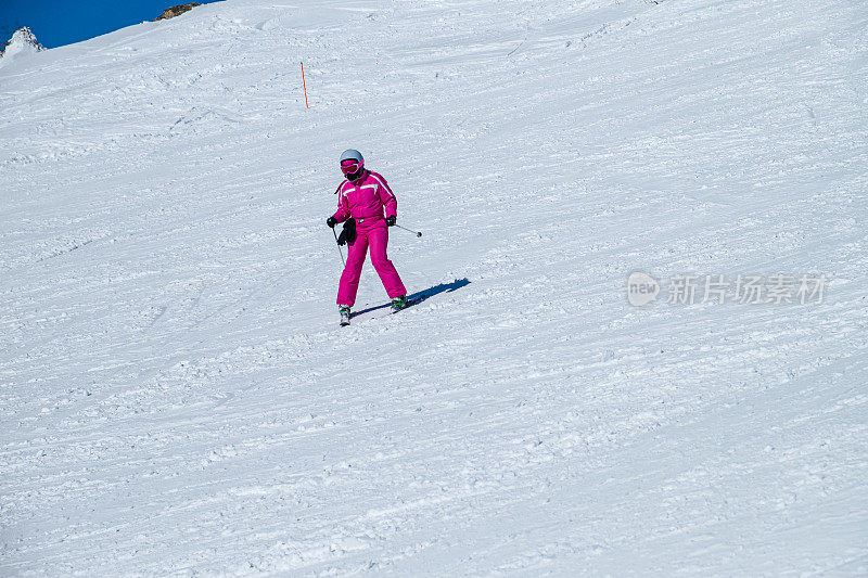 在一个阳光明媚的冬日，滑雪者享受着下坡的乐趣
