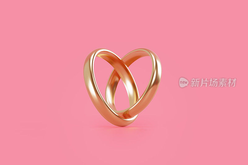 金结婚戒指形成一个心形粉红色的背景