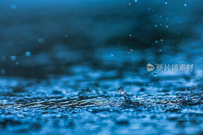 雨滴落在水坑里。下雨了。溅起的水