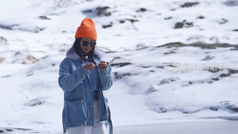 一个女人在寒冷的天气里穿行于白雪覆盖的山林之中