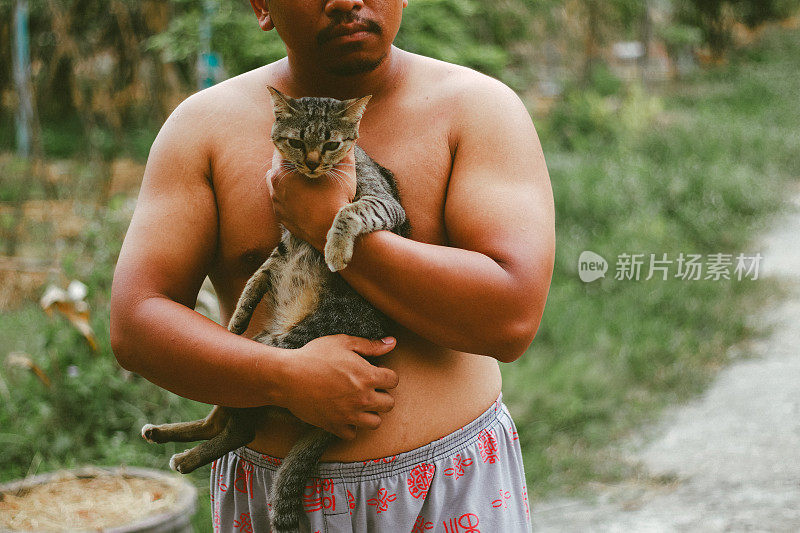 胖子和虎斑猫在玩