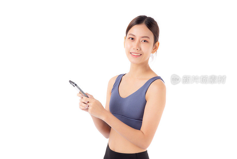 一个健康的年轻亚洲女性穿着运动服，使用智能手机，可能是在管理她的健身计划，孤立的白色背景，活跃的女性在运动服、运动和健康方面使用智能手机。