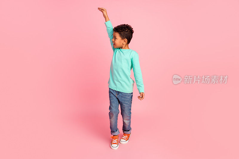 迷人小男孩的全尺寸照片测量显示身高穿时髦的海蓝宝石服装孤立在粉红色的背景