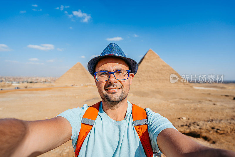在开罗吉萨金字塔前自拍的年轻人