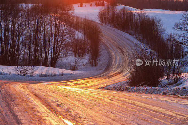 日落时被冰雪覆盖的道路