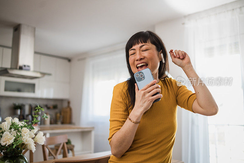 一位年轻漂亮的人字拖女沉浸在自己的音乐世界里，通过无线耳机听着自己最喜欢的歌曲。