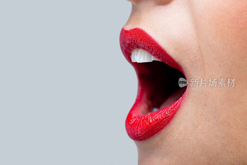 女人的嘴张得大大的，涂着红色的口红。