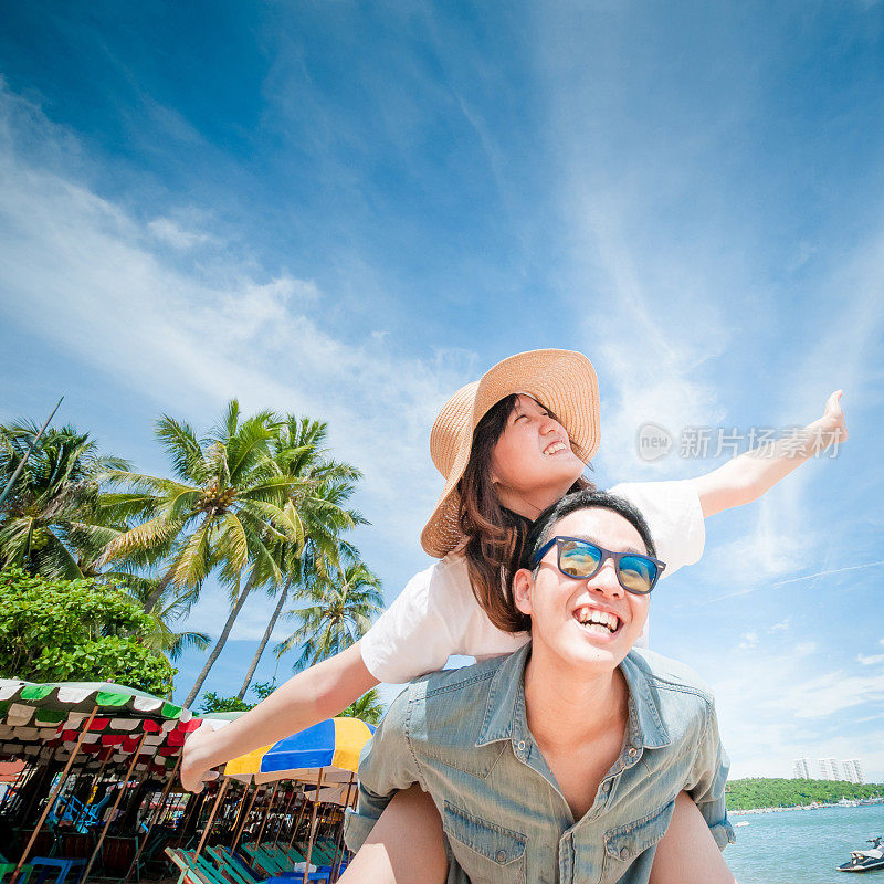 男人在海滩上让女人骑在背上。