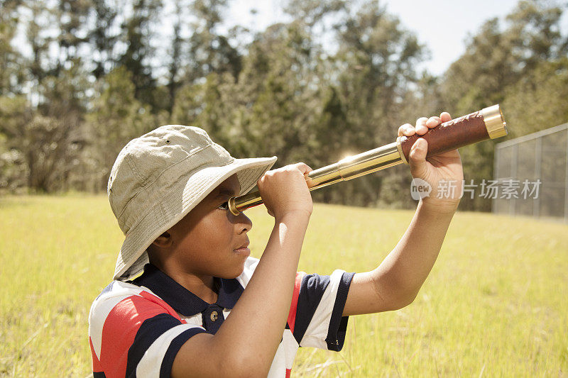 孩子们:小男孩在公园或校园里使用望远镜。
