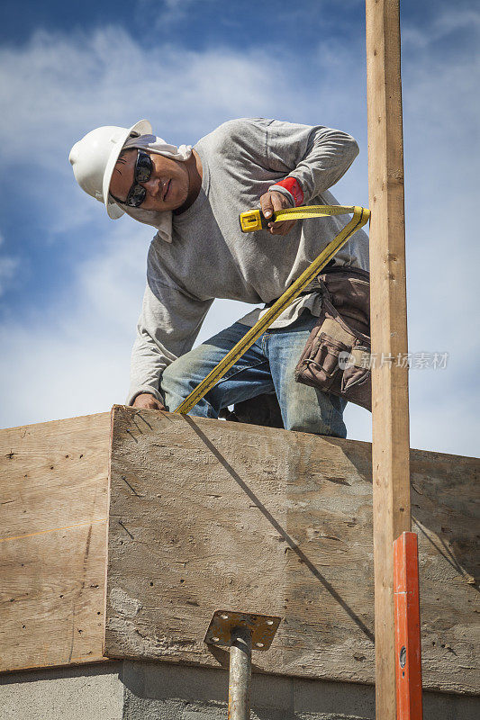 建筑工人测量垂直板的距离