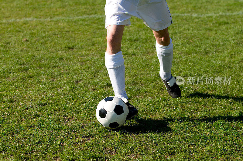 足球运动员脚上接着球跑得很快