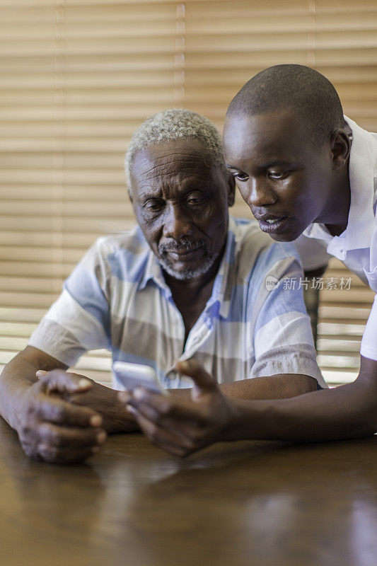 非洲孙子教他爷爷如何使用手机