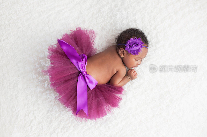 刚出生的小女孩穿着紫色的芭蕾舞裙