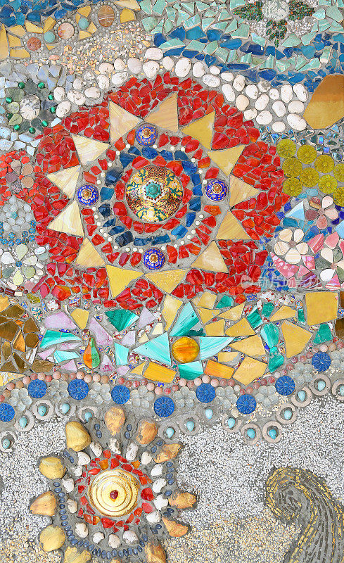 墙上用鹅卵石和陶瓷制作的彩色陶瓷图案背景。