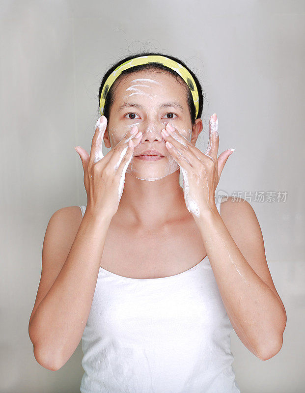 女人在脸上涂抹泡沫霜