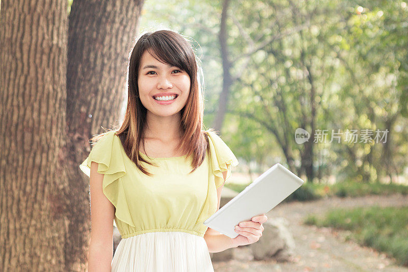 亚洲女学生在校园里用平板电脑的肖像