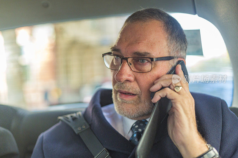 伦敦出租车上穿着得体的老人在打电话