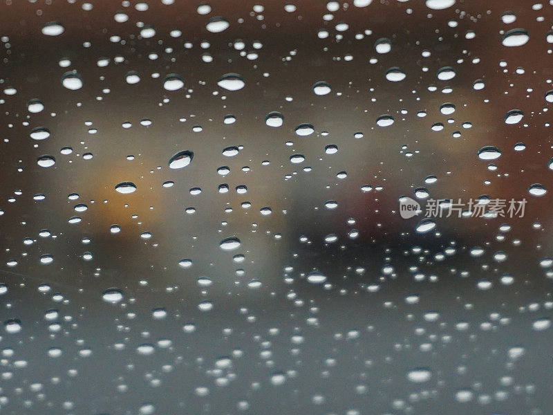 雨点落在车窗上，模糊了背景