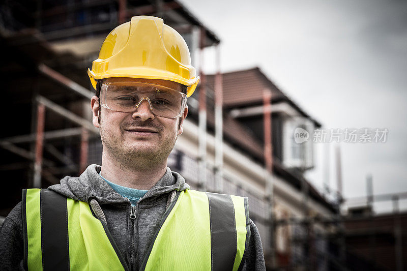 年轻建筑工人戴安全帽在建筑工地