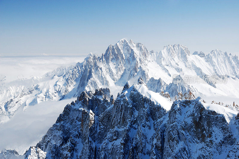 阳光照耀下的雪峰在白云密布的原野中，阿尔卑斯山