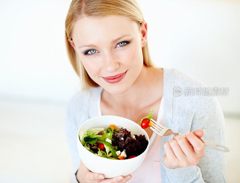 年轻女子吃沙拉