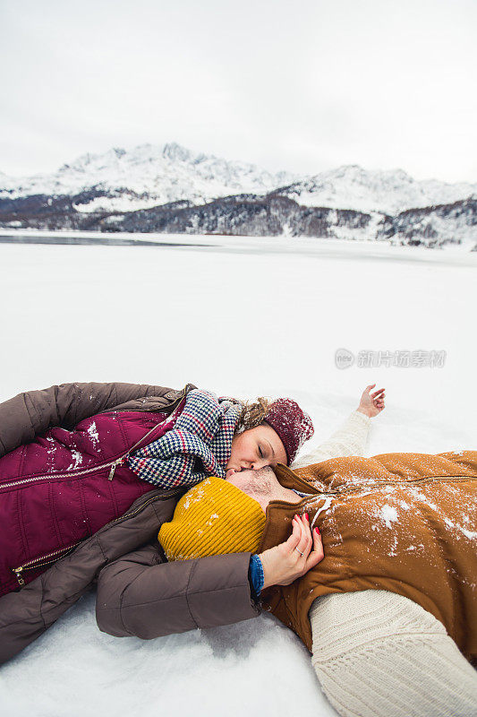 年轻美丽的夫妇在雪中玩耍