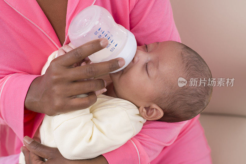 一个月大的婴儿在喝奶瓶里的牛奶。