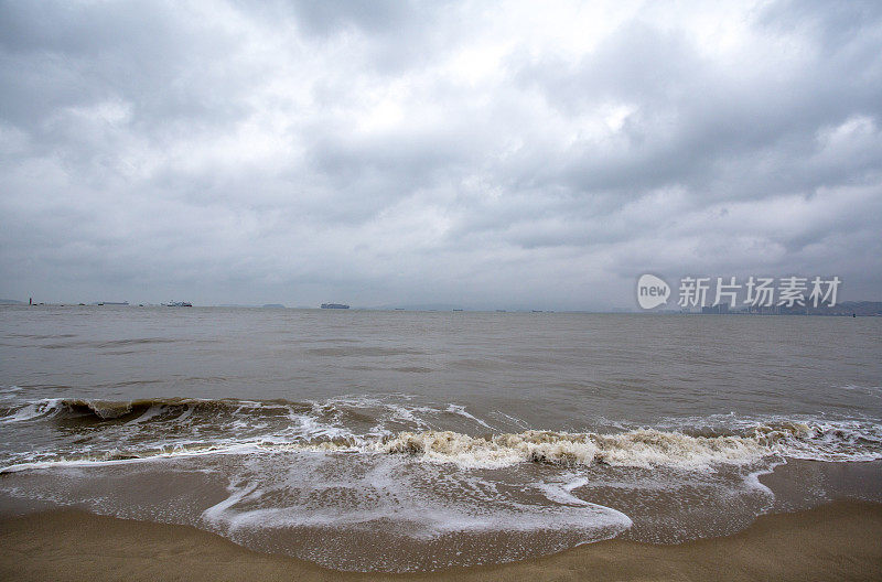 阴天下海浪在海滩上冲浪