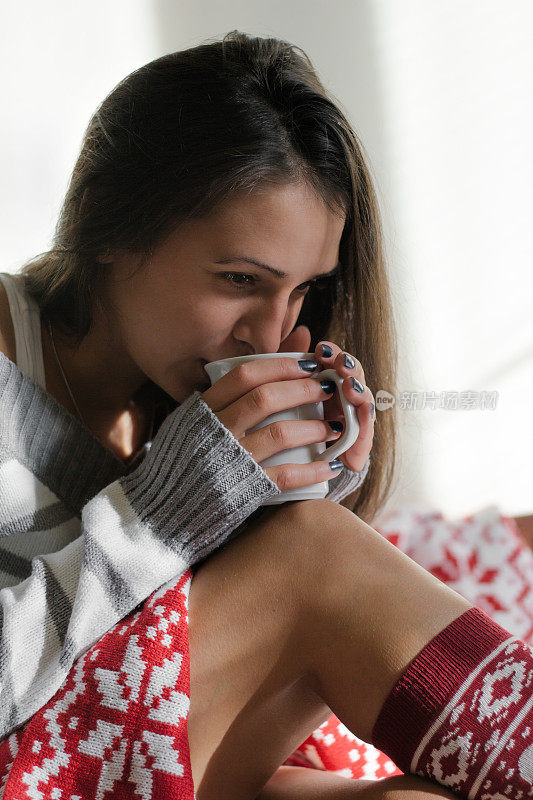 在床上喝热咖啡的女人