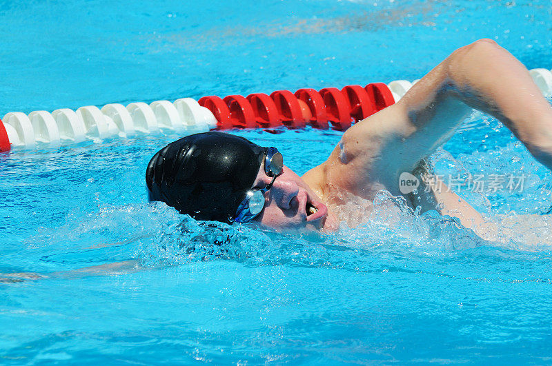 少年男子运动员自由式前爬泳在游泳池游泳
