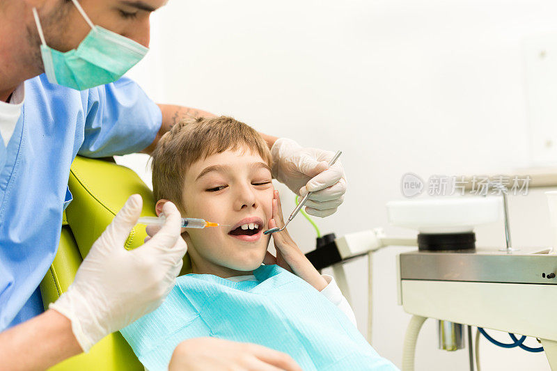 吓坏了的男孩在牙医诊所接受麻醉