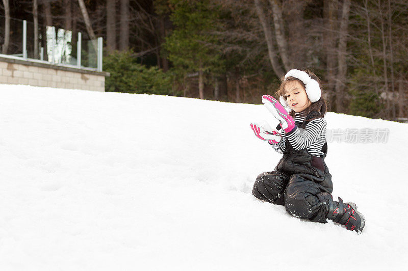 漂亮的小女孩在雪地里玩