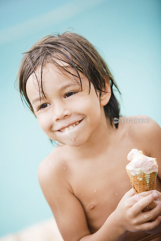 小男孩在泳池边吃冰淇淋