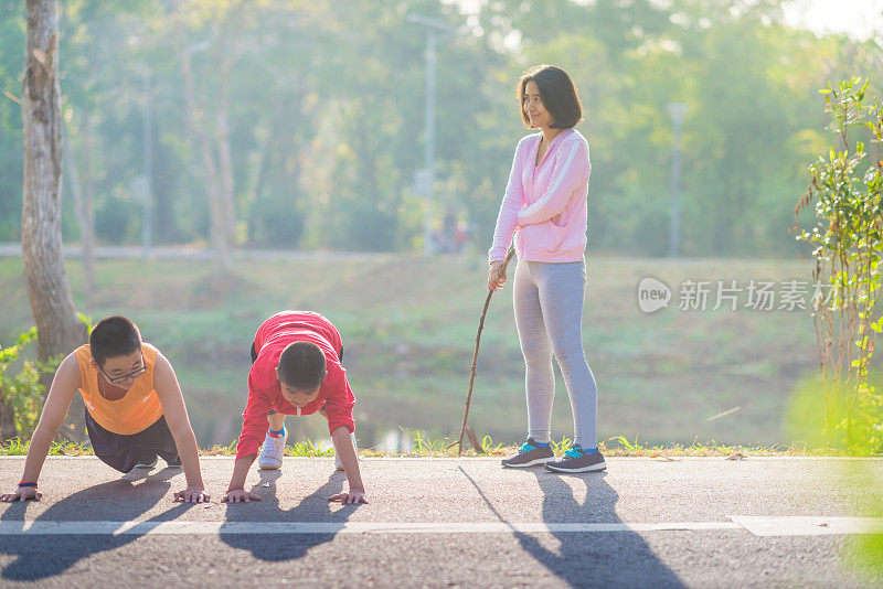 家庭运动快乐活跃的母亲和孩子在户外慢跑，在森林里跑步