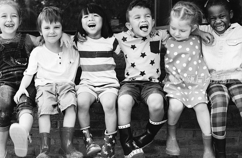 一群幼儿园小朋友朋友环抱而坐，笑口常开