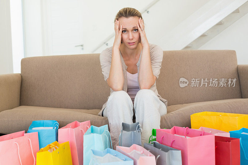 懊悔的女人看着沙发上的许多购物袋